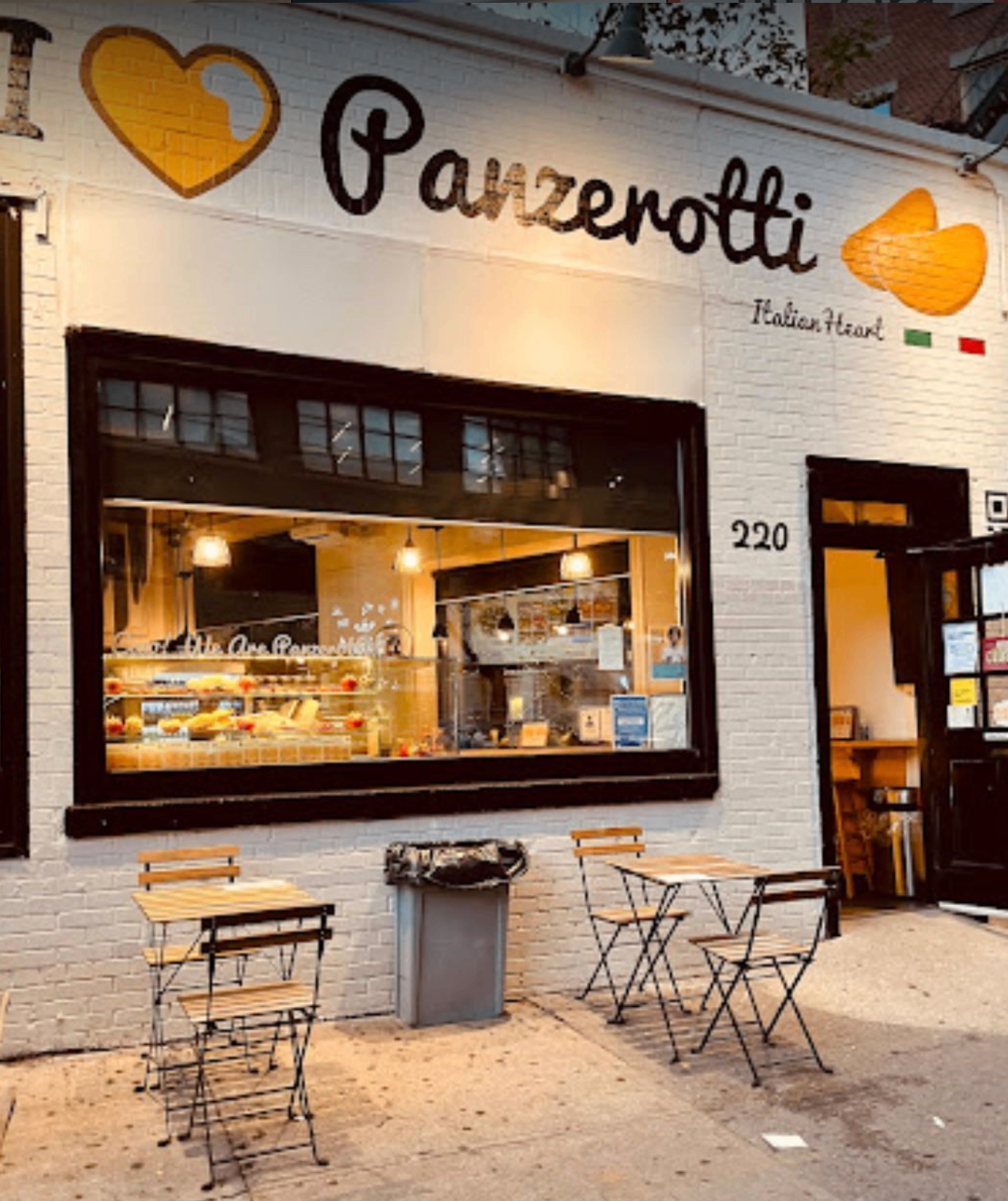Lo store di Varick Street di sera con i tavolini esterni